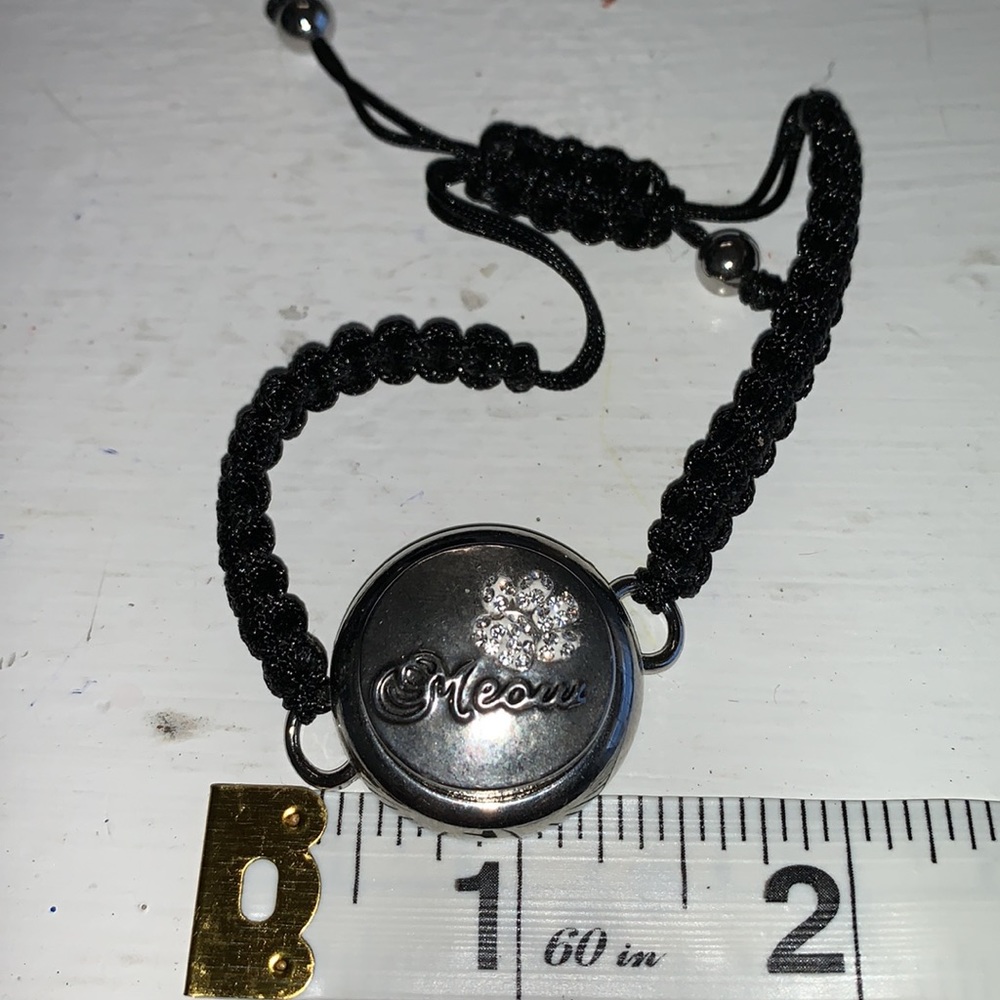 Adjustable braided black cord bracelet with one interchangeable snaps.NWOT